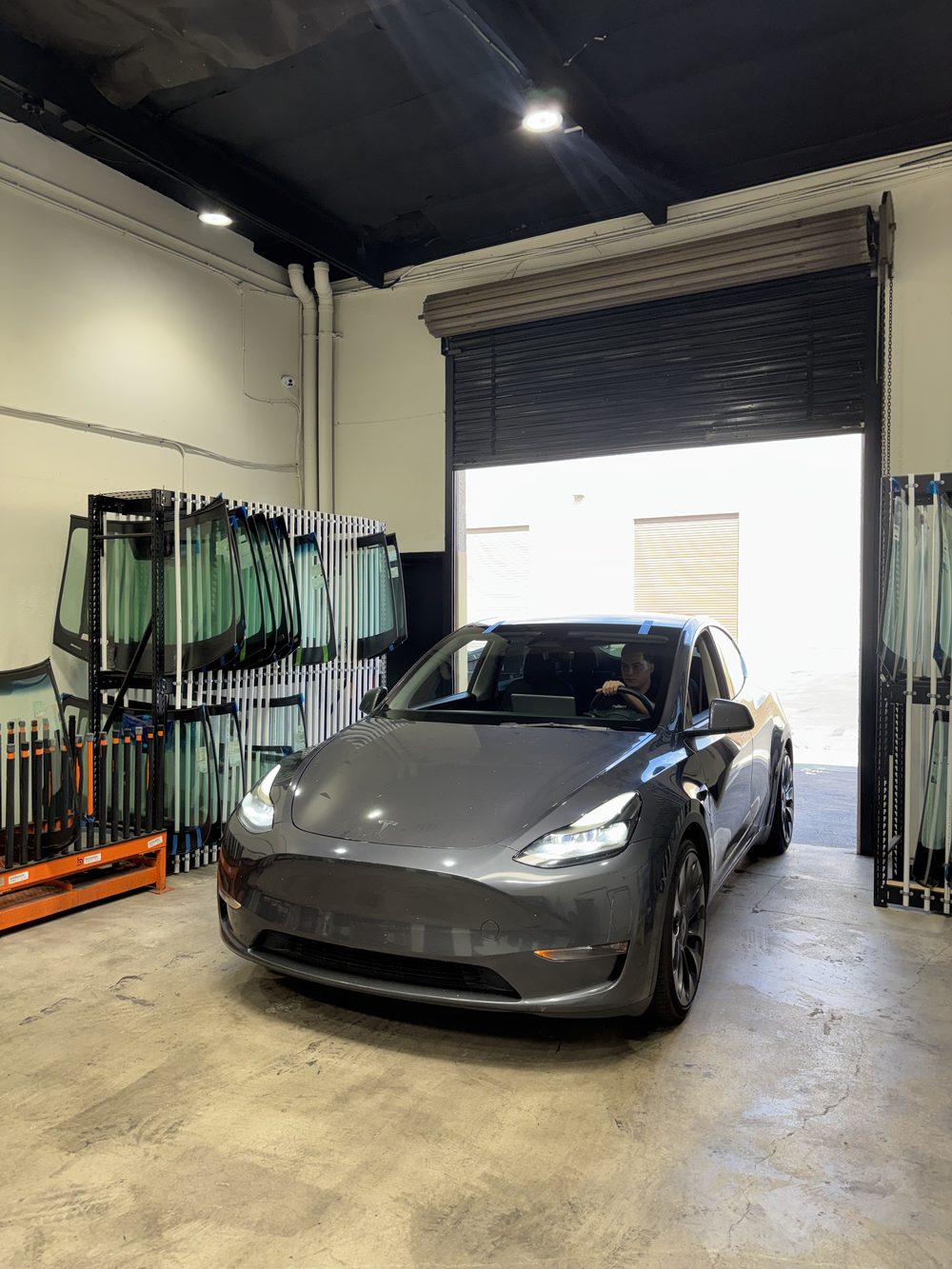 A Tesla Model Y at the Connect Auto Glass shop door