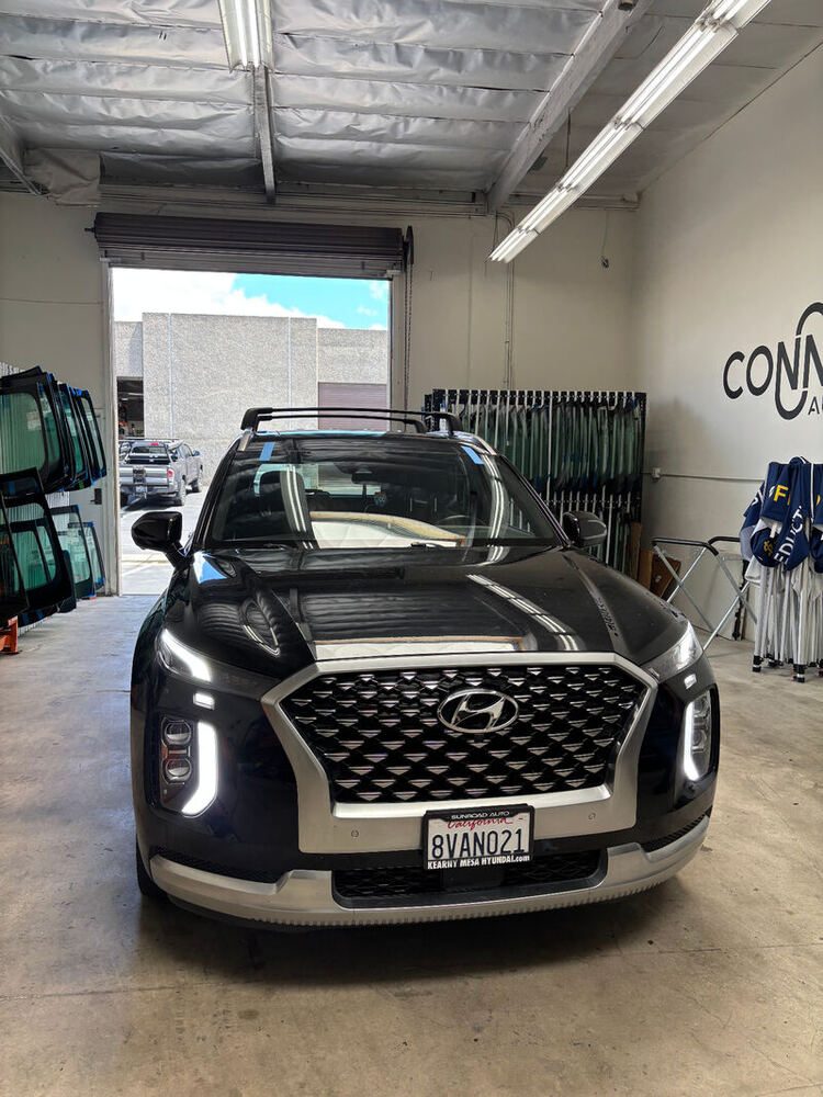 A Hyundai Palisade in the Connect Auto Glass shop with the glass racks